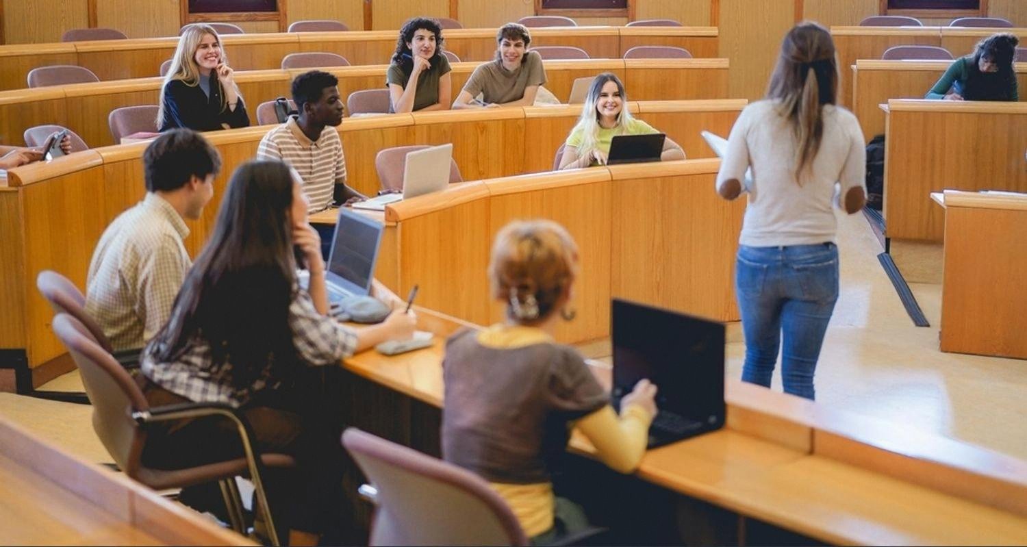 Students in a tiered lecture hall at a UAE university during a digital technology class